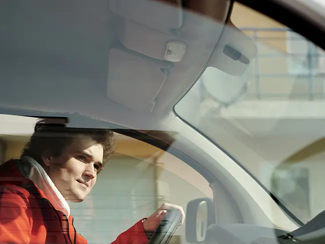 Car Insurance Considerations for your Small Business: Windshield Damages A small business driver looking through the windshield as he arrives at his destination.