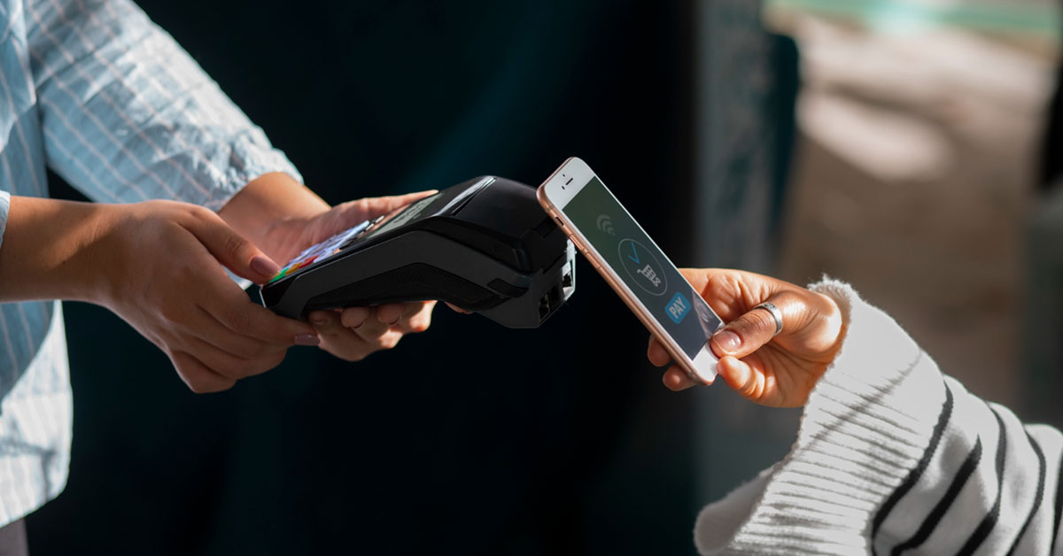Close-up of a person making a contactless payment using a smartphone at a point-of-sale terminal, highlighting mobile payment security