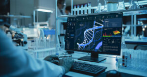 Scientist working in a biotechnology laboratory analyzing DNA sequences on a computer screen surrounded by lab equipment and test tubes.