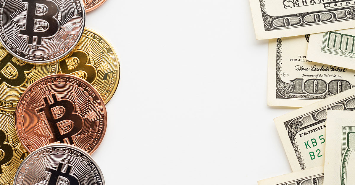Arrangement of physical Bitcoin tokens next to U.S. dollar bills—symbolizing the comparison between cryptocurrency and traditional currency for business use.