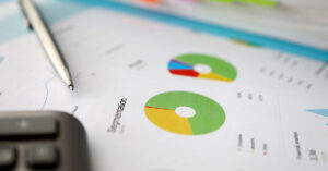 Close-up of colorful pie charts and graphs labeled “Segmentation” on printed reports—highlighting marketing statistics and trends for small businesses.