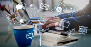Person typing on laptop surrounded by digital marketing icons representing communication, analytics, and online business promotion strategies.