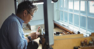 Focused artisan working meticulously on a design prototype in a workshop, symbolizing creativity, precision, and success in the 3D printing business.