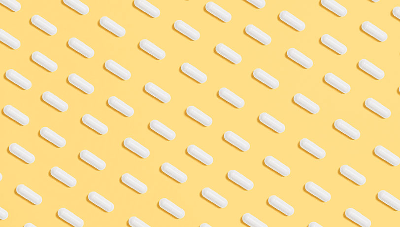 A pattern of diagonal lines built from medicine pills against a yellow background.