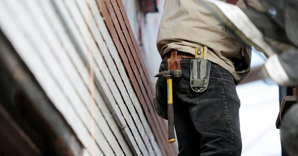 Construction worker with a hammer attached to his utility belt