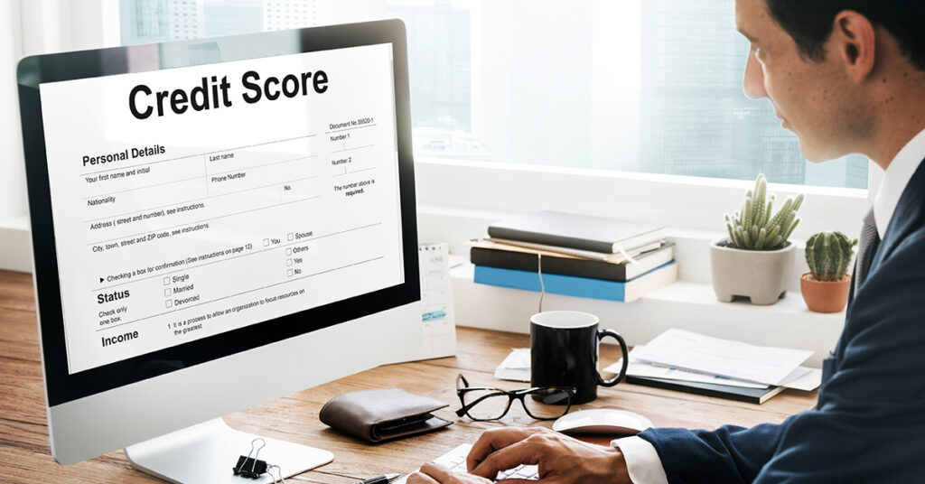 Business professional checking a credit score report on a computer screen in a modern office, highlighting the importance of monitoring business credit health.