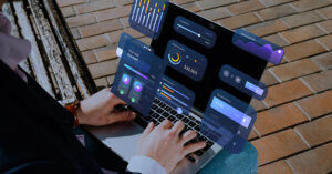 Person using a laptop with virtual financial dashboards and analytics, representing cloud-based accounting software and digital finance management for small businesses.